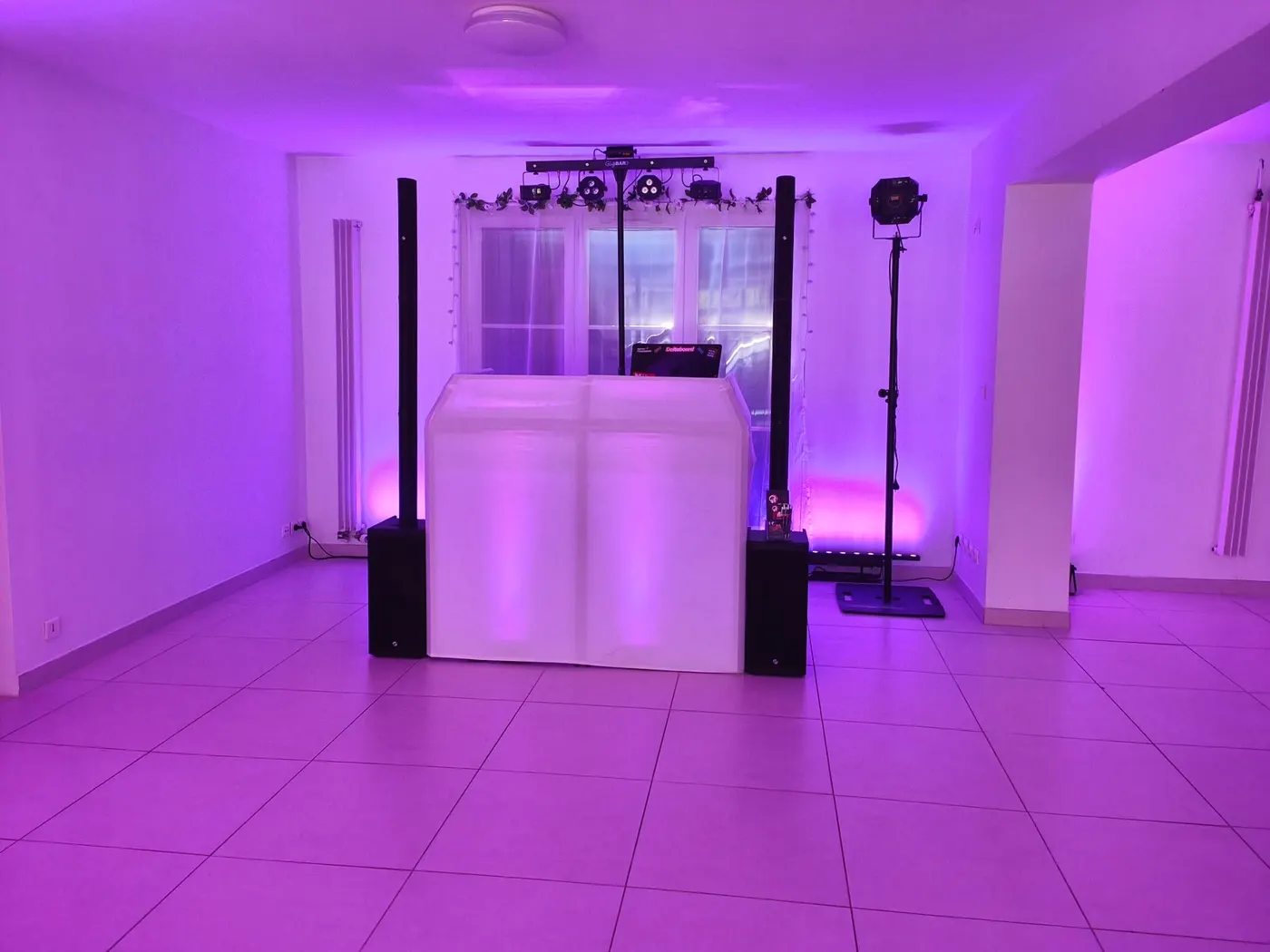 Installation DJ dans une salle blanche éclairée en violet